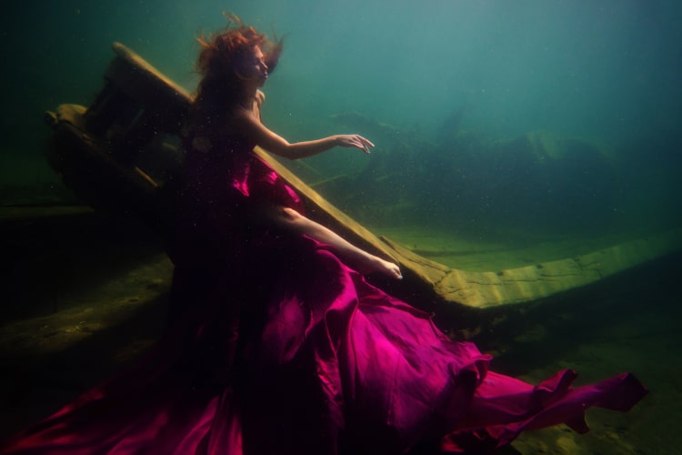 woman underwater in maroon dress for for the deepest underwater portrait shoot